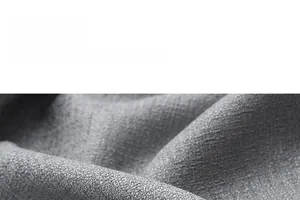 Close-up of grey textured curtain fabric showing smooth drape and silky weave details
