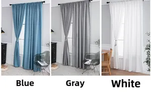 Detail of semi-sheer curtains with pom-pom trim in blue, gray and white tones