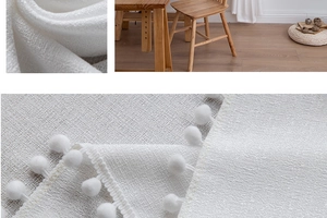 Macro detail of white linen fabric featuring elegant pom-pom fringe trim for curtains