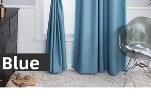 Blue semi-sheer curtain detail with decorative pom-pom trim and elegant textured fabric