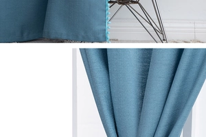 Close-up of blue blackout curtains with pom-pom trim and heavy fabric texture