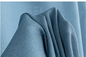 Close-up of blue woven curtain fabric texture with elegant drapes and soft shadows