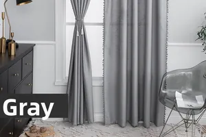 Detail of grey curtain with pompom fringe and white tassel tieback in a modern room