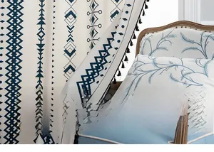 Detail of bohemian cotton linen curtain with blue geometric patterns and black tassels