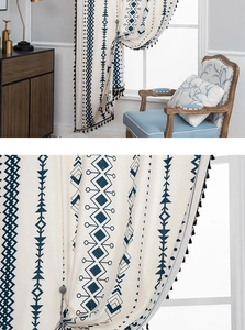 Detail of Bohemian cotton linen curtain with blue geometric patterns and black tassels