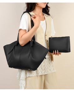 Detail of black pebbled leather tote set with knotted handles and matching clutch pouch