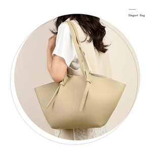 Close-up of beige wing-shaped tote bag showing premium lychee pattern leather texture