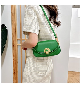 Mannequin portant un sac sous le bras en cuir vert vif avec boucle fer à cheval dorée