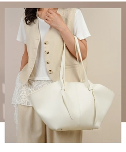 Minimalist white winged tote bag with lychee texture leather detail shown on shoulder