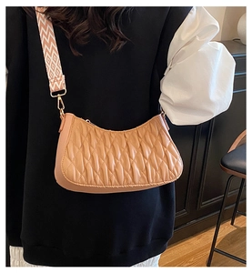 Détail du sac bandoulière plissé en cuir avec une large sangle tissée géométrique