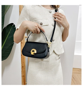Détail du sac selle minimaliste en cuir noir avec son fermoir doré étagé particulier