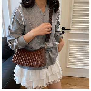 Détail du sac hobo plissé marron avec large bandoulière au motif ethnique géométrique