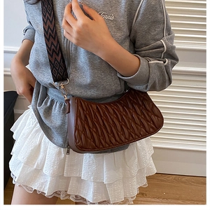 Détail du sac croissant froncé marron foncé avec large bandoulière en tissu géométrique