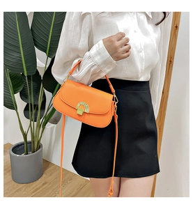 Mannequin portant un sac besace vintage orange avec boucle dorée et bandoulière