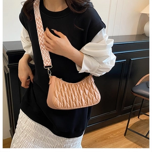 Détail du sac demi-lune matelassé rose pêche avec une large bandoulière graphique