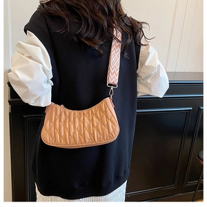 Gros plan du sac en croissant plissé beige avec large bandoulière à motifs pour femme