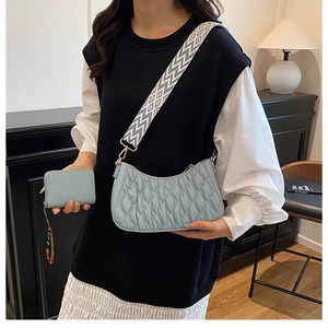 Détail du sac à bandoulière matelassé bleu clair avec sangle large et mini pochette