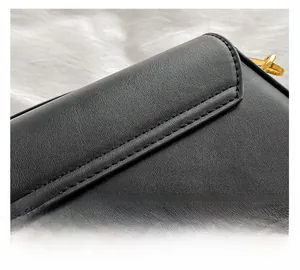 Gros plan des coutures fines et détails dorés sur un sac bandoulière en cuir noir
