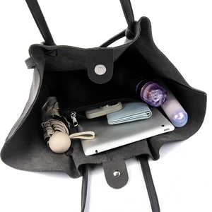 Large black leather tote bag showing spacious interior with tablet and daily essentials