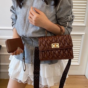 Brown pleated leather crossbody bag with bamboo handle and patterned shoulder strap