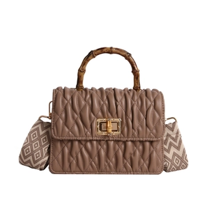 Brown pleated leather handbag with bamboo handle and patterned wide strap