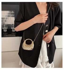 Detailansicht der goldfarbenen Acryl-Abendtasche mit Steppmuster und rundem Metallgriff