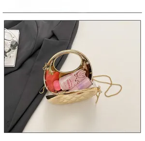 Draufsicht der offenen goldenen Abendtasche zeigt Platz für Lippenstift und Handcreme