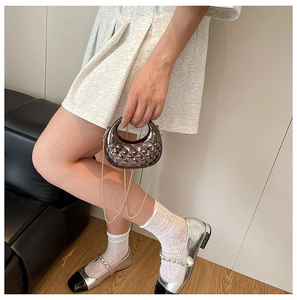 Detailaufnahme der gesteppten Mini-Abendtasche mit goldener Kette und Rautenmuster