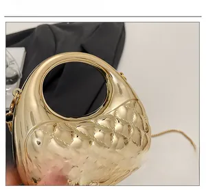 Detailansicht der goldenen Abendtasche aus Acryl mit Rautenmuster und rundem Griff