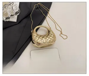 Detailsicht der mini goldfarbenen Stepptasche mit Metallkette und Größenvergleich