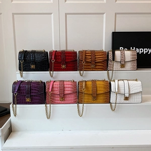 Multi-color crocodile pattern chain crossbody bags with gold B-shaped buckles on display