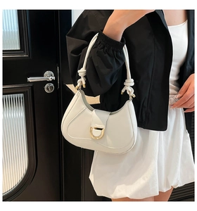 Detail of white hobo bag showing the gold D-ring buckle and knotted handle texture