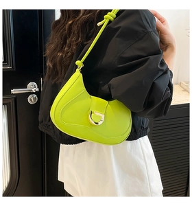 Détail du sac croissant vert citron avec boucle en D argentée et bandoulière nouée