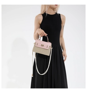Détail du rabat en cuir rose et du tissage beige de ce sac bandoulière stylé en paille