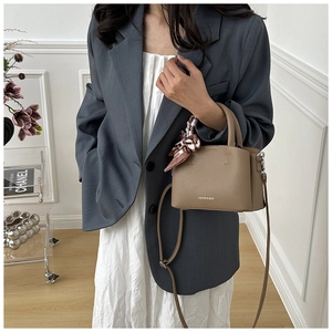 Detail of soft khaki leather bucket bag with silk scarf handle and FASHION & BAGS logo