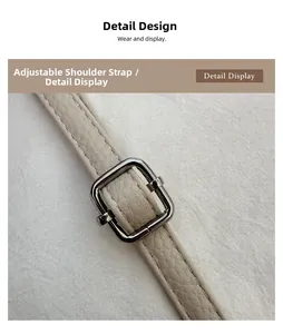 Detail of adjustable cream leather shoulder strap with a silver square metal buckle