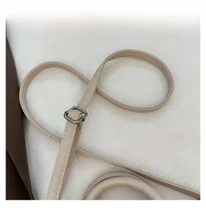 Close-up of adjustable soft leather shoulder strap with silver buckle and litchi texture