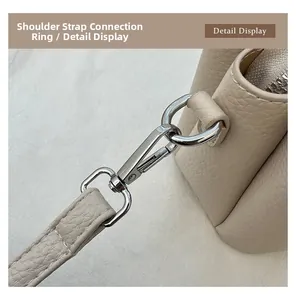 Macro shot of silver metal buckles and stitching on a beige pebbled leather handbag
