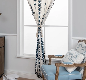 Close-up of bohemian linen curtain with geometric prints and black tassel details