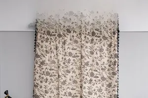 Detail of bohemian floral print beige cotton linen curtain with black side tassels