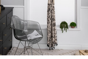 Detail of bohemian cotton linen curtain featuring black floral prints and elegant tassels
