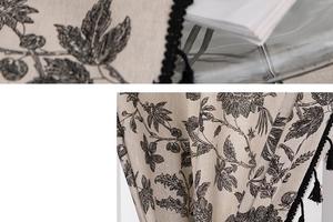 Detail of bohemian cotton linen curtain with floral print and black tassel trim