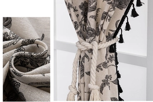 Detail of floral American style curtain featuring black fringe trim and cotton rope tie