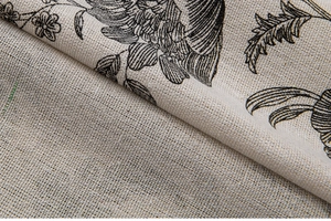 Macro shot of linen-textured fabric with traditional black floral print on beige curtain