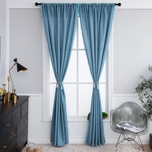 Fog blue cotton linen curtains with pom-pom trim and tassel tiebacks in a modern room