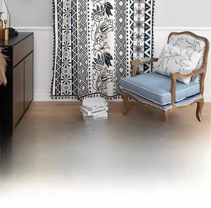 Detail of bohemian cotton linen curtain with black floral patterns and pom-pom tassels
