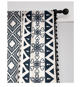 Detail of bohemian curtain showing navy blue geometric patterns and black handmade tassels