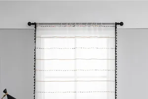 Detail of white semi-transparent sheer curtain with colorful stripes and black tassels