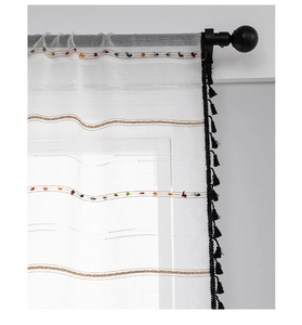 Detail of white semi-transparent curtain with wave texture and black tassel fringe