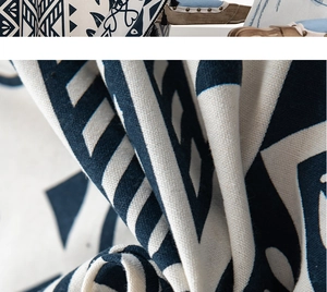 Detail of bohemian geometric woven fabric in navy and beige with tassels